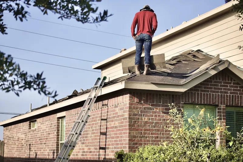 Professional roofer working on a residential roof in Mills Farm